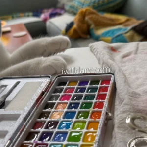 A watercolor palette and a cat